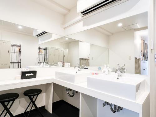 een badkamer met 2 wastafels en een grote spiegel bij Osaka Nipponbashi EVISU HOSTEL in Osaka