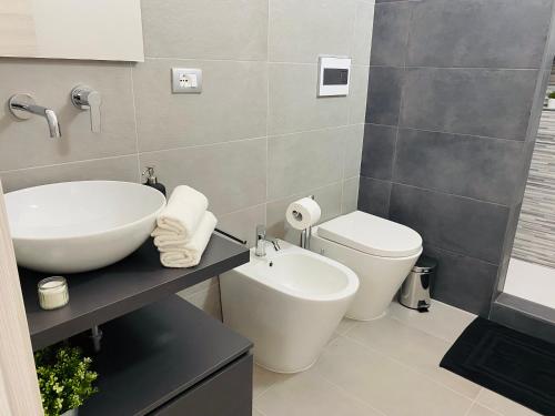 a bathroom with a sink and a toilet at Sicilian Rooms in Avola