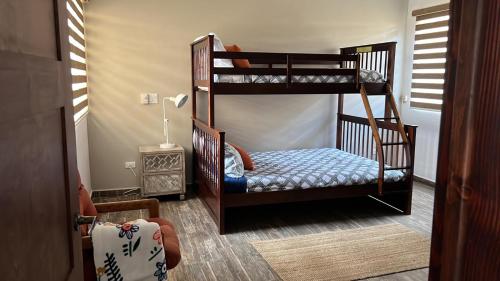 a bedroom with two bunk beds and a chair at Casa Relax en La Mision, gran vista, chimenea in Rosarito