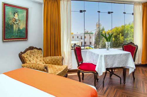 a room with a table and chairs and a window at Hotel Plaza San Antonio Arequipa in Arequipa
