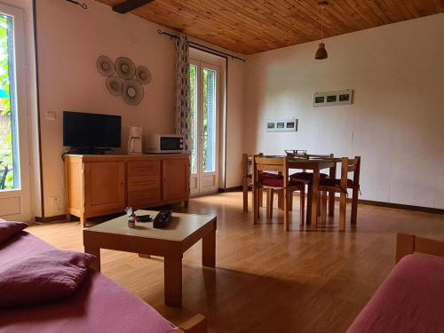 un salon avec une table et une salle à manger dans l'établissement Charmant Gîte avec Activités Extérieures et Auberge sur Place à La Chabanne - FR-1-489-187, à La Chabanne