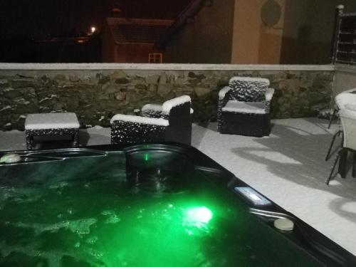 une baignoire jacuzzi avec de la neige au-dessus dans l'établissement Gîte de Charme avec Spa, Hammam et Vélo Électrique près du Parc du Pilat - FR-1-496-8, à Cellieu