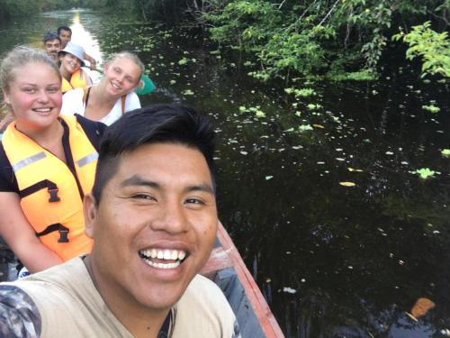 a man in a boat on a river with people at Amazon Jaguar Adventure & Lodge in Iquitos
