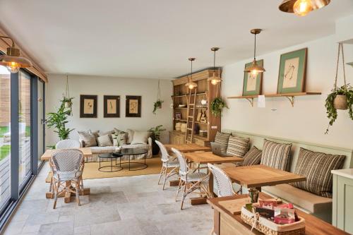 a living room with a couch and tables at Les pénates bordelaises - Maison d'hôtes - Guesthouse in Bordeaux
