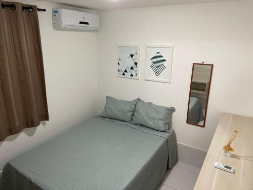 ein kleines Schlafzimmer mit einem Bett und einem Spiegel in der Unterkunft Chalé Serra Nevada - Bananeiras in Bananeiras