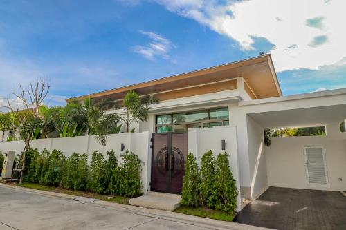 a white house with a purple door at Shambhala grand villa by Cozy Lake in Bang Tao Beach