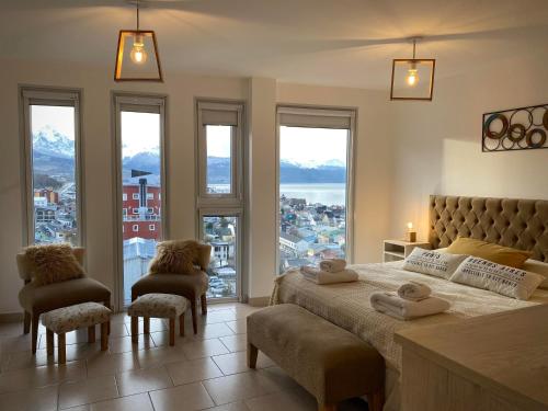 a bedroom with a bed with a view of a city at Infinity View Pent House I in Ushuaia