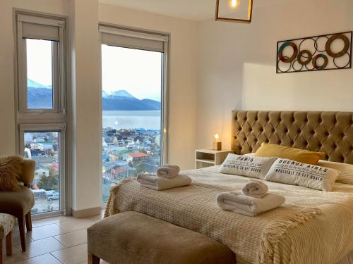 a bedroom with a large bed with towels on it at Infinity View Pent House I in Ushuaia