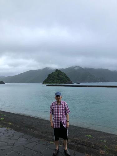 a man standing in front of a body of water at Guest in Shallman in Amami