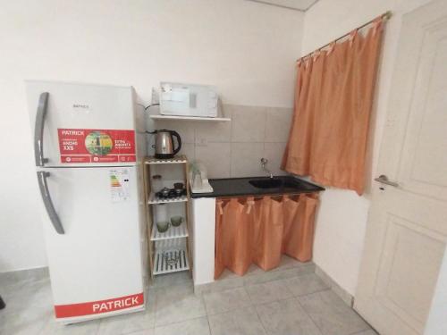 a small kitchen with a refrigerator and a sink at Zona Sur Apart in Salta