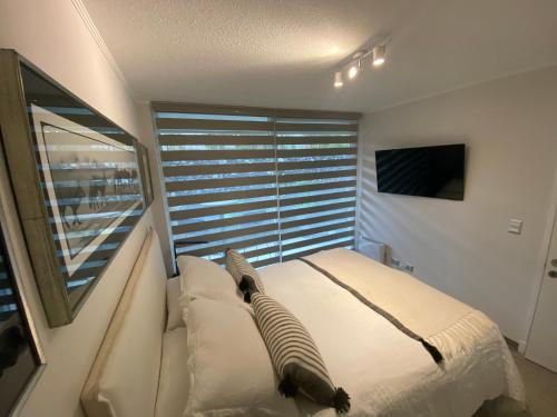 a bedroom with a bed and a large window at Departamento Pucon in Pucón