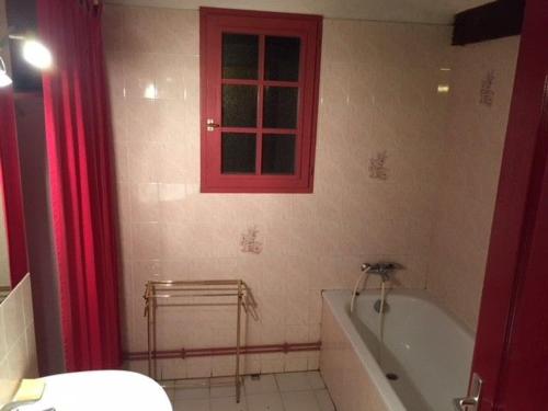a bathroom with a red window and a bath tub at Gîte Coullons, 4 pièces, 6 personnes - FR-1-590-18 in Coullons