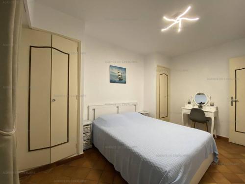une chambre avec un lit blanc et un bureau dans l'établissement Bel appartement T3 climatisé, centre Cavalaire, proche plages et commerces - FR-1-100-273, à Cavalaire-sur-Mer