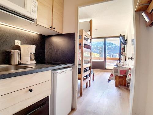 une cuisine avec un évier et un plan de travail dans l'établissement Studio agréable Ski au pieds Balcon - FR-1-344-979, aux Menuires