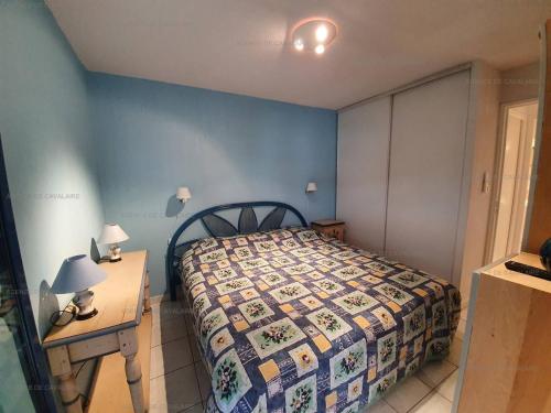 1 dormitorio con 1 cama y 1 mesa con 2 lámparas en Appartement Cavalaire-sur-Mer, 2 pièces, 4 personnes - FR-1-100-277, en Cavalaire-sur-Mer