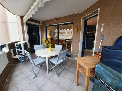 une terrasse avec une table et des chaises ainsi qu'une salle à manger dans l'établissement T2 climatisé au cœur de Cavalaire, avec terrasse, garage, proche des plages et commerces - FR-1-100-277, à Cavalaire-sur-Mer
