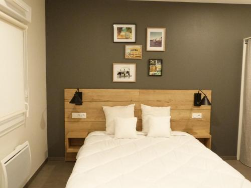 a bedroom with a large white bed with four pillows at Appartement PMR 4 pers, plage, piscine chauffée, parking, animaux admis - FR-1-194-254 in La Tranche-sur-Mer