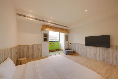 a bedroom with a large bed and a flat screen tv at Shineworld 11 in Shalu