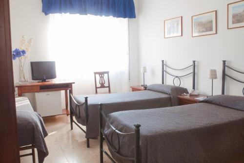 a hospital room with three beds and a television at Hotel Antico Acquedotto in Rome
