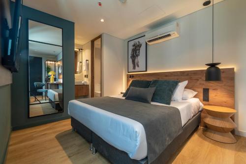 a bedroom with a large bed and a table at Hashtag 98 Hotel By Jalo in Medellín