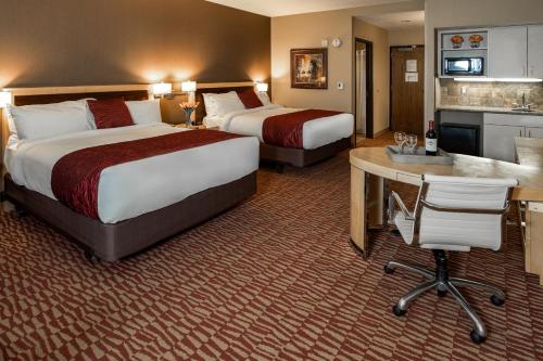 a hotel room with two beds and a desk and a kitchen at Lakeside Hotel Casino in Osceola