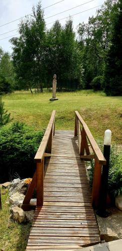 a wooden bridge with a bench on top of a field at Chata Anna in Nižné Hágy