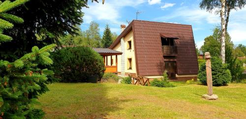 a house with a brown roof in a yard at Chata Anna in Nižné Hágy