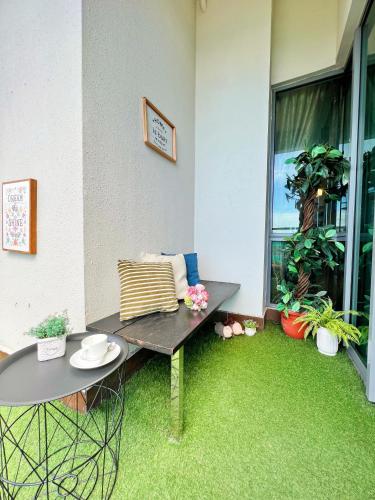 a patio with a bench and a table and some plants at Maison life 小居屋 The Loft Imago in Kota Kinabalu