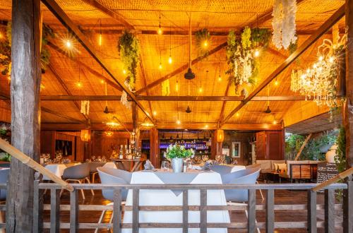 a dining room with white tables and chairs at La Bastide de Caro in Siem Reap