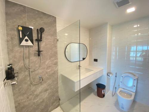 W łazience znajduje się prysznic, toaleta i lustro. w obiekcie Mayuu Ayutthaya Hotel w mieście Ban Ko Rian
