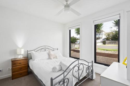 een witte slaapkamer met een bed en een raam bij Portarlington Gem in Portarlington