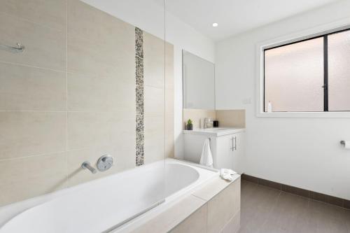 Un baño blanco con bañera y ventana. en Portarlington Gem, en Portarlington