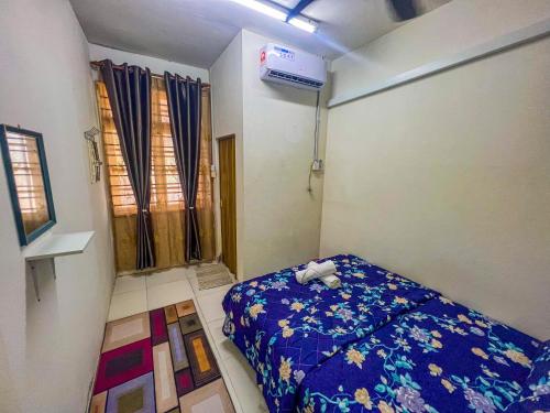 a small room with a bed and a air conditioner at Nail Guest House Kuala Besut in Kampong Nail