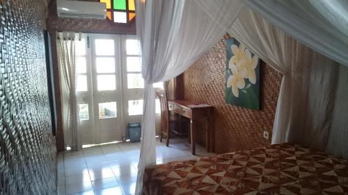 a bedroom with a bed and a window at Zen inn in Padangbai