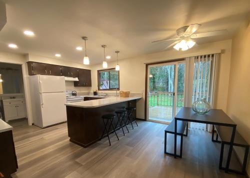 a kitchen with a refrigerator and a table at Fern Hill Retreat in Chehalis