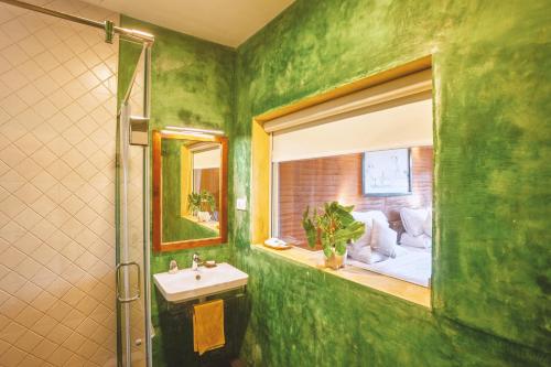 a green bathroom with a sink and a window at AMARA AYURVEDA RETREAT- Overlooking Evergreen Western Ghats an ecologically sustainable living space in Kovalam in Kovalam