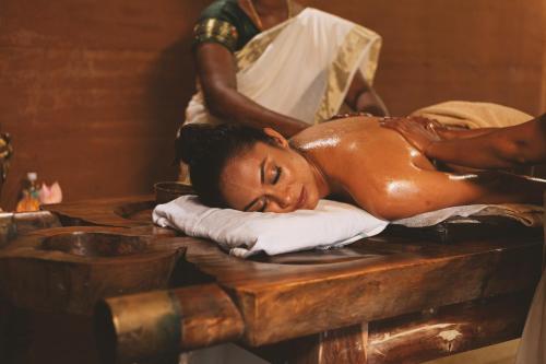 a woman getting a massage at a salon at AMARA AYURVEDA RETREAT- Overlooking Evergreen Western Ghats an ecologically sustainable living space in Kovalam in Kovalam