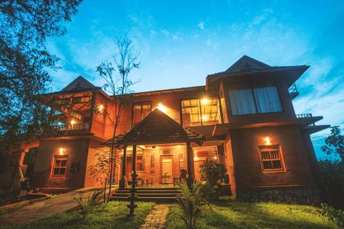 a large house with lights on the front of it at AMARA AYURVEDA RETREAT- Overlooking Evergreen Western Ghats an ecologically sustainable living space in Kovalam in Kovalam