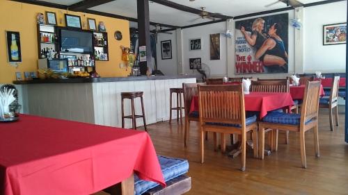 a restaurant with red tables and chairs and a bar at Zen inn in Padangbai