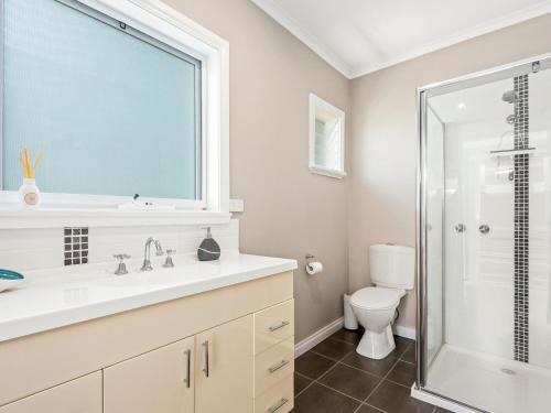 a bathroom with a toilet and a sink and a shower at Resarf Retreat in Portarlington