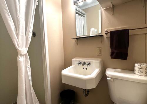 a bathroom with a sink and a toilet and a mirror at Whetstone Bay Lodge in Bonesteel