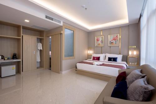 a hotel room with a bed and a couch at Elegant Airport Hotel in Bangkok