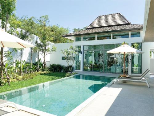 a villa with a swimming pool and a house at Shambhala grand villa by Cozy Lake in Bang Tao Beach