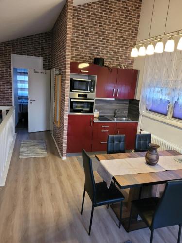 uma cozinha com armários vermelhos, uma mesa e cadeiras em King Panorama mit Netflix em Sankt Englmar