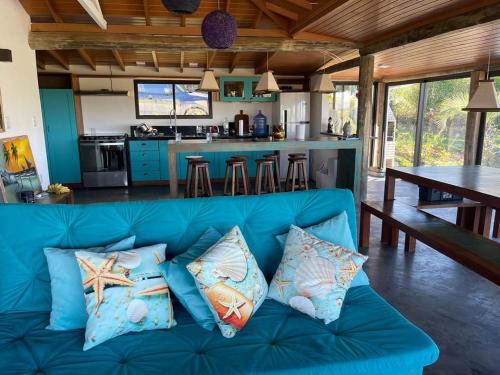 ein blaues Sofa mit Kissen darauf in einer Küche in der Unterkunft Villa Santorini Praia do Rosa com piscina e jacuzzi in Praia do Rosa