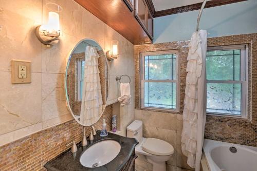 Un baño con lavabo, inodoro y espejo. en Corpus Christi Home with Pool and Hot Tub Walk to Bay, en Corpus Christi