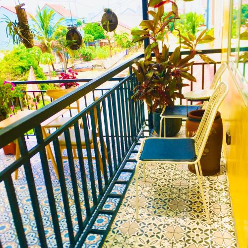 a balcony with a chair and plants on a balcony at An Bang Sea Adventure Homestay Hoi An in Hoi An