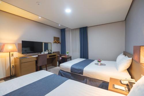 Tempat tidur dalam kamar di Benikea Hotel Jeju