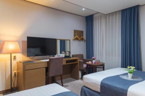 Ένα ή περισσότερα κρεβάτια σε δωμάτιο στο Benikea Hotel Jeju
