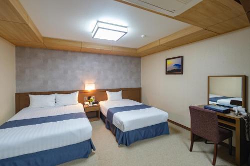 Ένα ή περισσότερα κρεβάτια σε δωμάτιο στο Benikea Hotel Jeju
